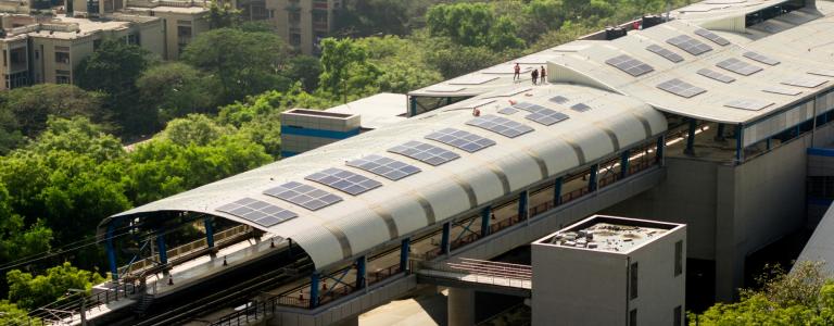 An aerial view of a metro station in Delhi with solar panels on the roof