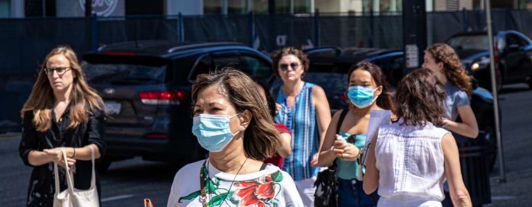 eople are crossing road with face masks on due to COVID-19 pandemic