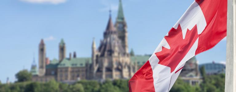 A Canadian flag waves in front of the parliament buildings in Ottawa