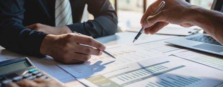 Business professionals review documents in an office.