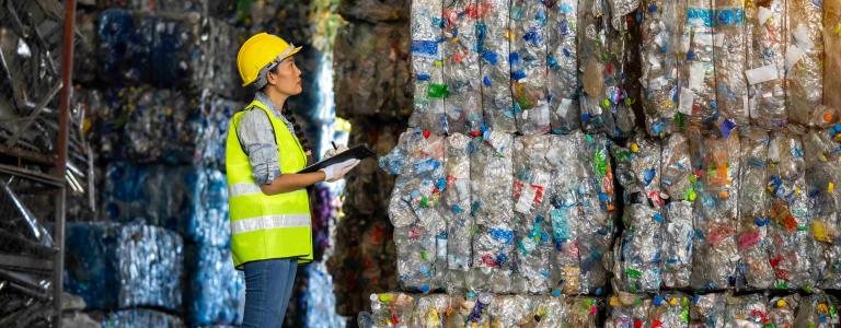 Female worker checks the stock and controls recyclable waste of plastic 