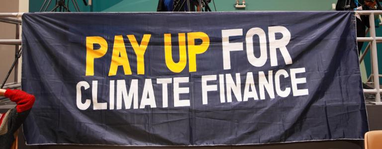 A banner at COP 29 reading: "PAY UP FOR CLIMATE FINANCE"