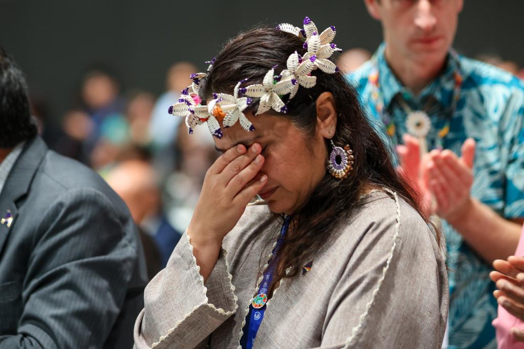 Moriana Philip, Marshall Islands, covers her tears at the close of COP 28