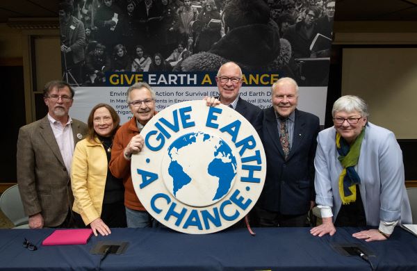 The founders of Earth Day sit at a long table at an event hosted by the University of Michigan
