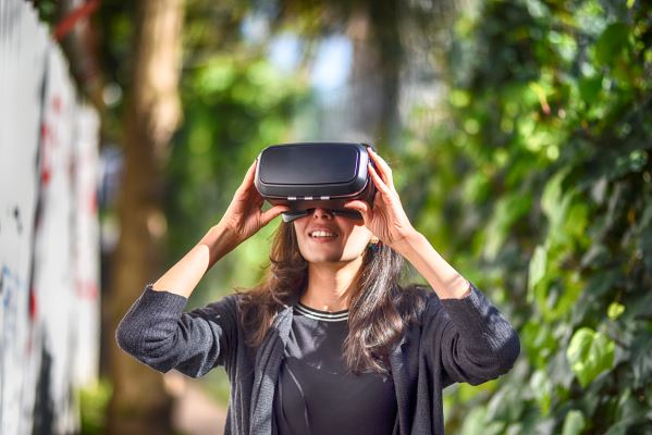 Woman wearing virtual reality glasses outside